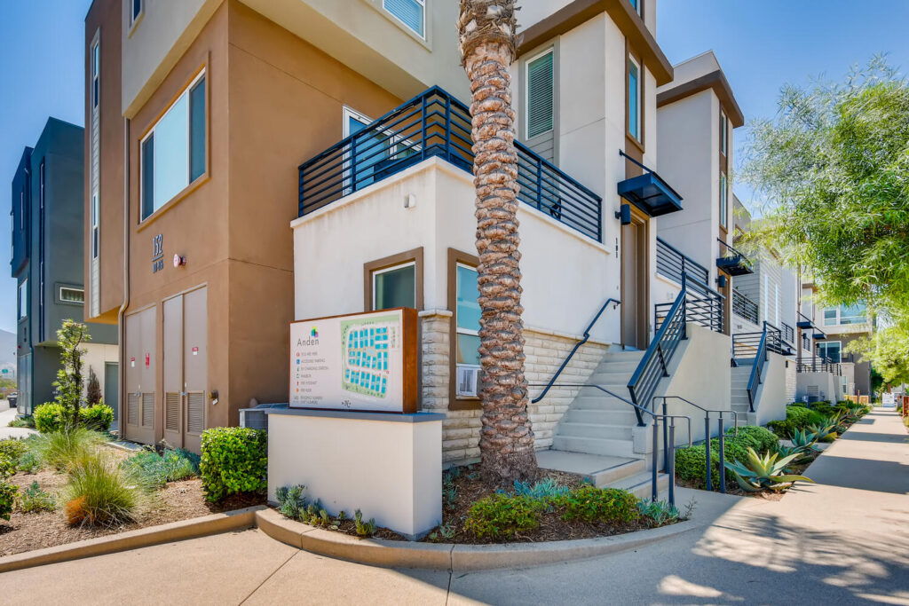 Building exterior with landscaped sidewalk and property map sign