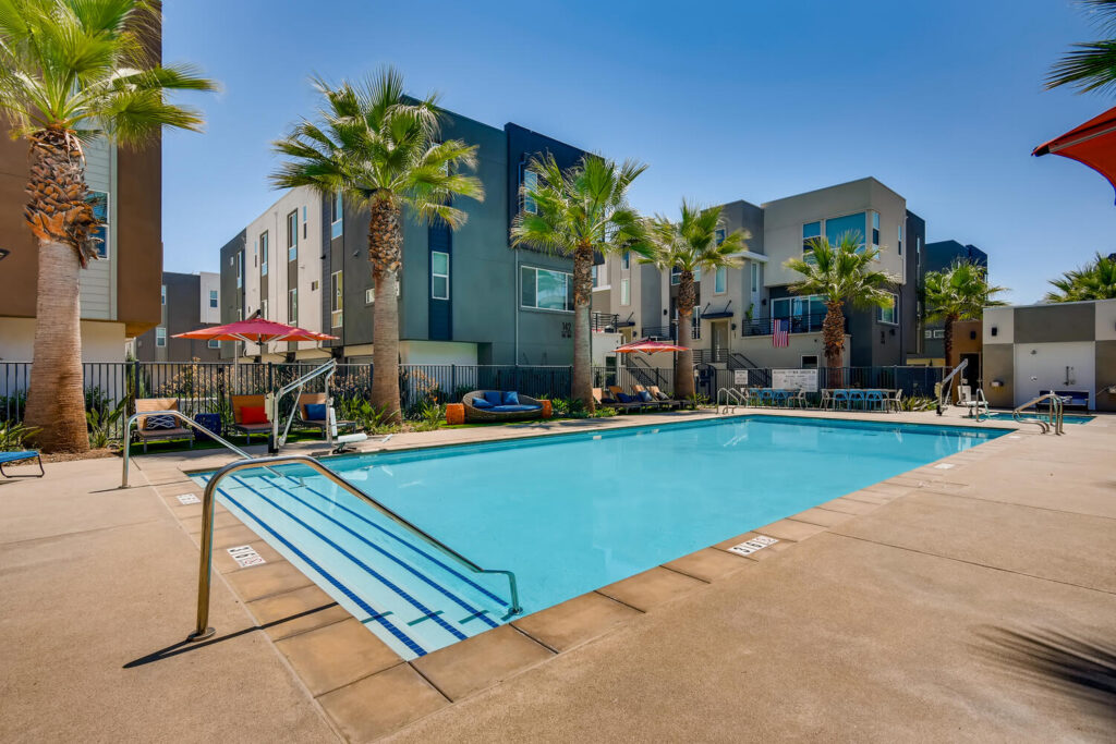 Pool with deck chairs at Anden townhome apartments in San Marcos