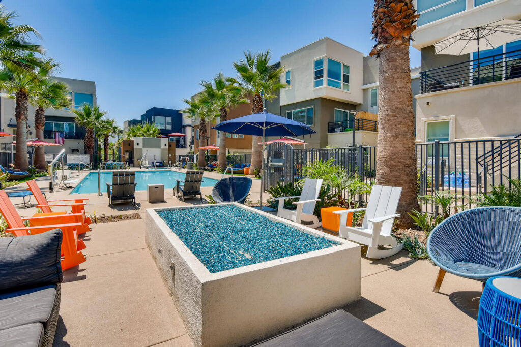 Sitting area by the pool with chairs around a fire pit