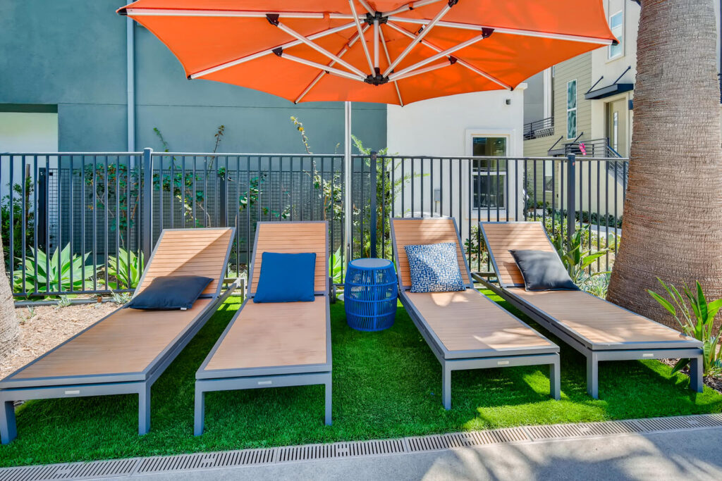 Reclining pool chairs with a large umbrella over them