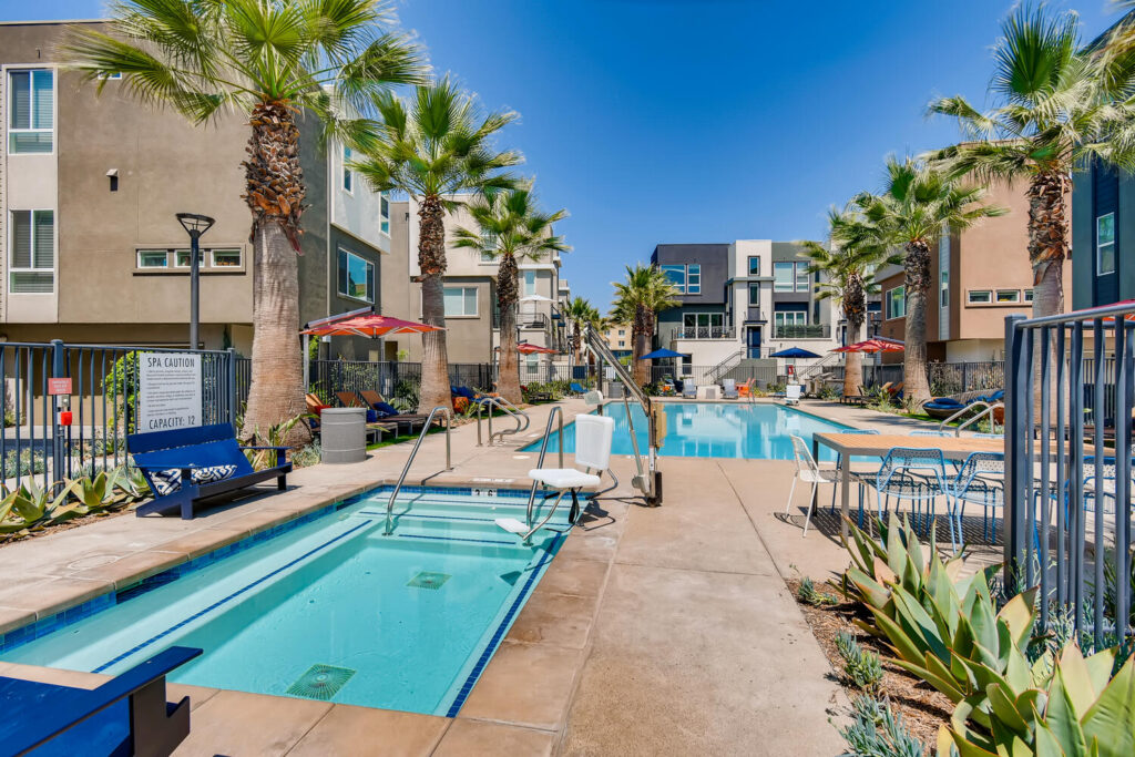 A large pool and a small pool with deck chairs and umbrellas