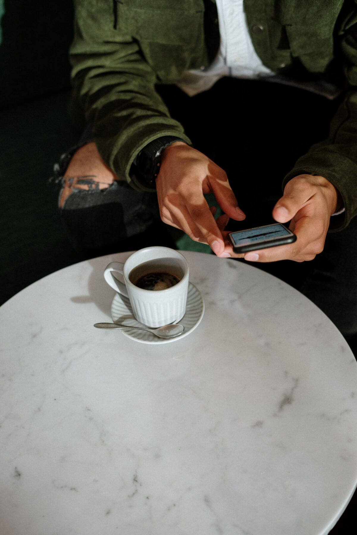 Man drinking coffee and looking at phone